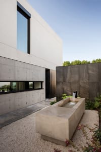 A minimalist modern house features a concrete exterior.
