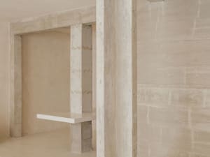 A serene minimalist interior design featuring concrete walls and flooring.