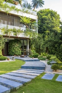 Modern residential exterior featuring concrete and lush greenery.