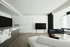 A modern living room featuring a white marble fireplace and a minimalist white sofa against a white wall.