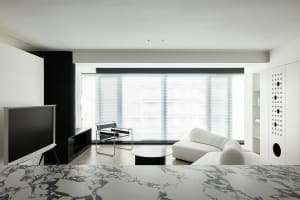 A modern living room with concrete walls and minimalistic furniture.