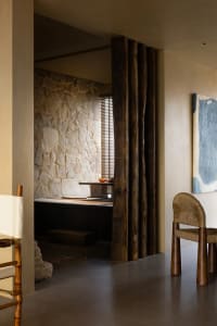A residential interior space featuring a stone wall and concrete floor.
