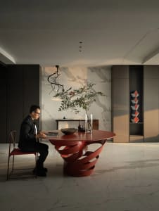 Man sitting at a minimalist office desk with a metal base and a marble top.