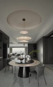 Modern dining room with marble flooring, metal and glass table, and red chair.