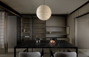 A minimalist dining room featuring a black marble table and fabric upholstered chairs.
