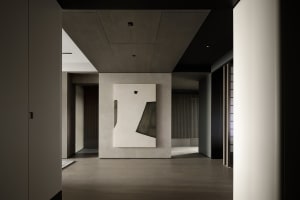 A modern interior featuring minimalist design with a prominent minimalist sculpture on a concrete wall.
