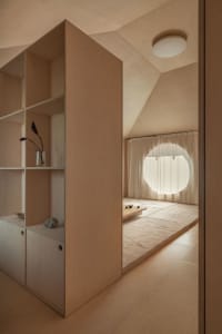 A minimalist room with wooden walls and a round window
