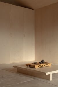 A minimalist interior design featuring wooden furniture and flooring.