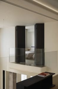 A minimalist bedroom features glass partitions and a sleek interior design.