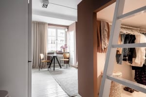 A minimalist white home office with white wooden floors, a white table, and white chairs.
