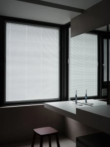 Bathroom interior featuring large windows with aluminum blinds.