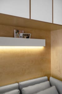 A modern residential interior featuring wooden paneled walls with built-in shelving.