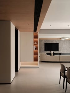 A modern living room featuring a composite wood, marble, and leather interior with a large television and plush seating.