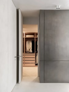 Modern minimalist closet with wooden shelves and drawers.