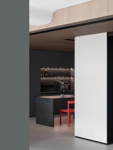 A modern minimalist kitchen with wooden cabinets and a glass dining table.