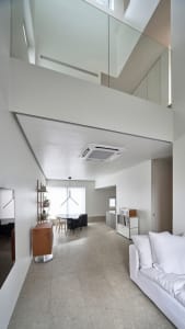 A modern living room with a minimalist design, featuring concrete walls and furniture.