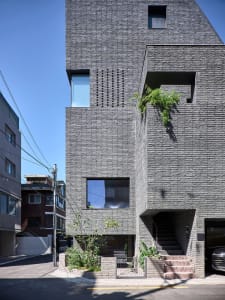 A modern residential house built with concrete, featuring geometric shapes and large windows.