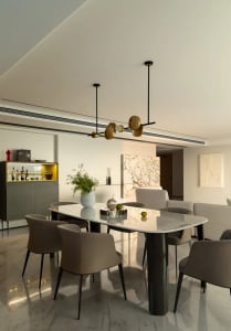 Modern dining room featuring a marble table and leather chairs, with a minimalist design.