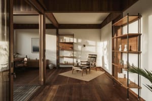 A modern minimalist living room with wooden shelves and furniture.