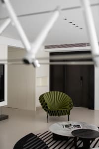 Minimalist interior featuring modern furniture and concrete and marble surfaces.