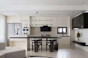 Minimalist kitchen with black countertops and white cabinetry and chairs
