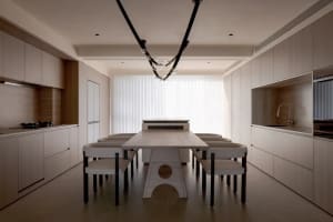Contemporary residential kitchen featuring a wooden table with metal legs and modern lighting