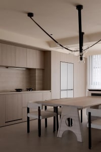 Modern residential kitchen with wood cabinetry, glass backsplash, and stainless steel appliances.
