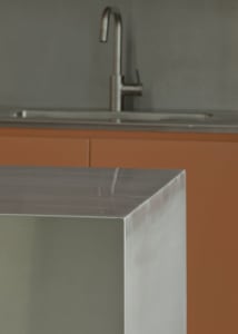 A sleek, modern kitchen featuring a stainless steel countertop and minimalist design.