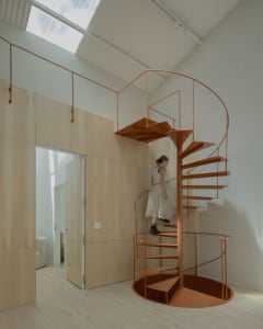 Woman climbing a minimalist metal staircase