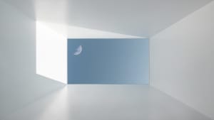 A minimalist interior design with an empty, white room and a clear view of the half-moon through a rectangular window.