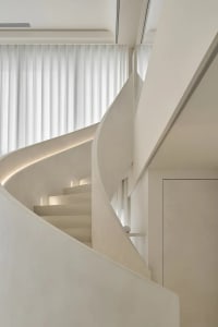 Modern minimalist staircase with concrete walls and hidden lighting in a sleek, contemporary interior design setting.