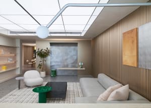 Modern living room with concrete and wooden elements and a grey sofa.