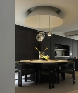 A modern dining room with a marble table and pendant lights above.