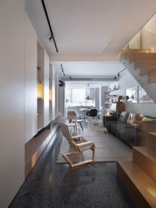 Modern minimalist living room with open shelving, wood furniture, and neutral color palette