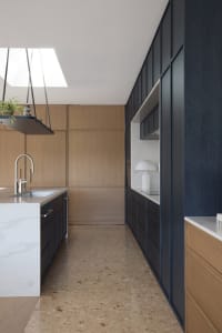 Modern minimalist kitchen featuring a sleek island with marble countertop and wooden cabinets.