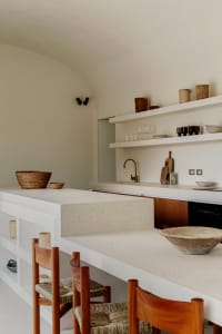 A minimalist kitchen featuring concrete and wood materials.