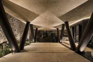 A modern entrance featuring a concrete structure with large pillars.