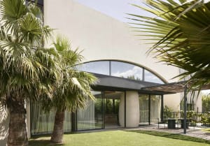 Modern residential exterior with large glass windows and a minimalist design.