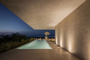 A minimalist residential patio featuring concrete surfaces and a modern design.