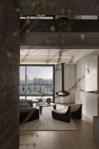Modern concrete living room with a suspended fireplace, large windows, and minimalist furniture.