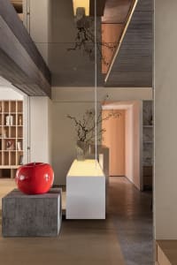 Modern residential entryway featuring concrete, wood, and glass materials