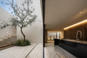 A modern kitchen with concrete floors, minimalist design, and a large island.