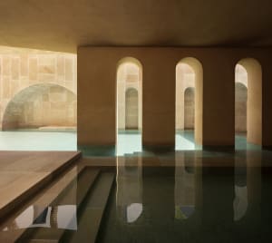 An indoor pool surrounded by modern concrete architecture.