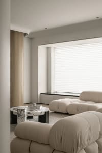 Modern minimalist living room with plush cushions and a large window