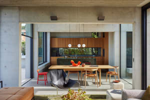 A modern kitchen with wood cabinets and a concrete floor.