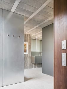 A modern, minimalist interior with metal walls and wooden panels.
