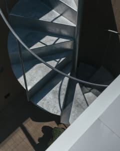 Concrete spiral staircase with industrial-style railing.