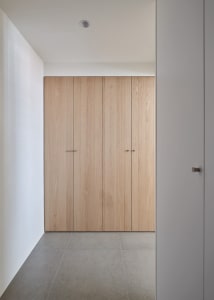 A minimalist closet with wooden doors and sleek design.