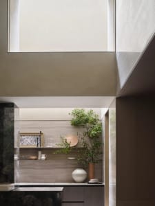 A modern minimalist interior with concrete walls, wooden shelves, glass elements, and marble accents.