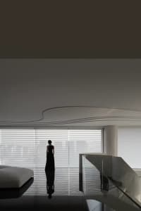 A sleek, minimalist living room with glass walls and steel accents.